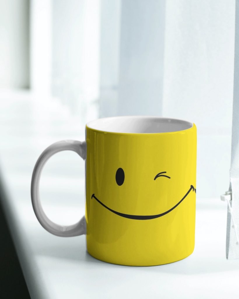 A cheerful yellow ceramic Coffee Mug Smiley with a smiley face design, ideal for coffee and tea enthusiasts.