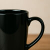 A personalized mug for a male boss featuring a custom design and his name, filled with coffee on a professional desk.
