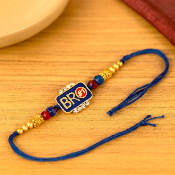 A trendy "Bro Rakhi" featuring a minimalist design, perhaps a metallic charm saying "BRO" or a cool geometric pattern, displayed casually on a wrist, representing a modern sibling bond.