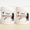 A white ceramic "Happy Anniversary Mug" featuring elegant black and red "Happy Anniversary" text, hearts, delicate leaf patterns, and a silhouette of a loving couple,