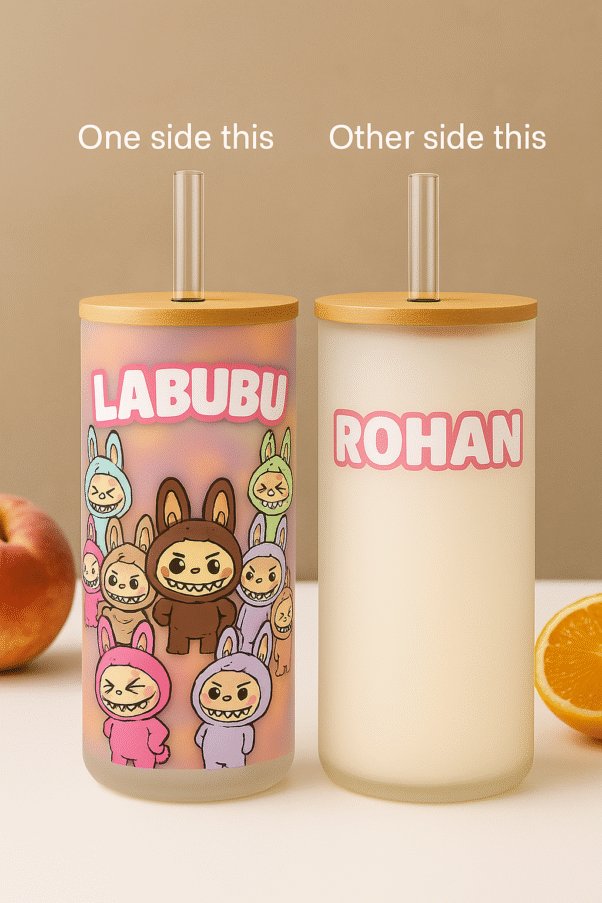 Two views of a Custom Name Labubu Tumbler for Kids: one side shows "LABUBU" text with multiple Labubu characters, the other side shows the personalized name "ROHAN." Both tumblers have a wooden lid and a clear straw.