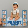 A Wooden cutout photo for baby customized featuring a smiling baby (Pranit) sitting on a cloud-shaped base, flanked by two blue vertical panels with four small baby photos each, and text indicating "PRANIT 1st BIRTHDAY" with balloons and a cake icon.
