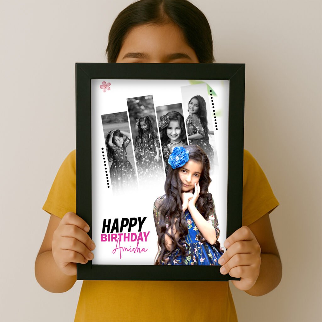 A black-framed Birthday Photo Frame for Baby Girl [cite: in mockup.jpg] held by a child, featuring a collage of five photos of a smiling girl (Amisha), with "HAPPY BIRTHDAY Amisha" text in white and pink, and decorative dots and a flower icon.