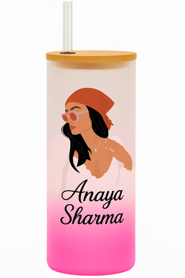 A white and pink gradient Personalized Tumbler for Girls with a bamboo lid and clear straw. One side features an illustration of a stylish girl with a red bandana and sunglasses, and the name "Anaya Sharma." The other side has "MAIN CHARACTER ENERGY" text with star accents.