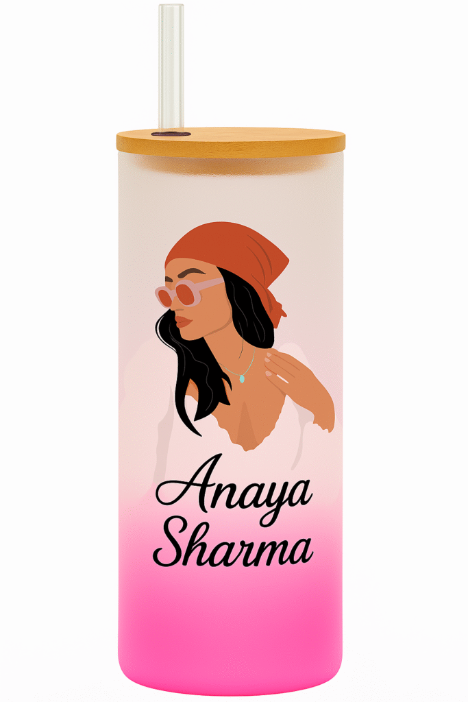 A white and pink gradient Personalized Tumbler for Girls with a bamboo lid and clear straw. One side features an illustration of a stylish girl with a red bandana and sunglasses, and the name "Anaya Sharma." The other side has "MAIN CHARACTER ENERGY" text with star accents.