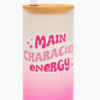 A white and pink gradient Personalized Tumbler for Girls with a bamboo lid and clear straw. One side features an illustration of a stylish girl with a red bandana and sunglasses, and the name "Anaya Sharma." The other side has "MAIN CHARACTER ENERGY" text with star accents.