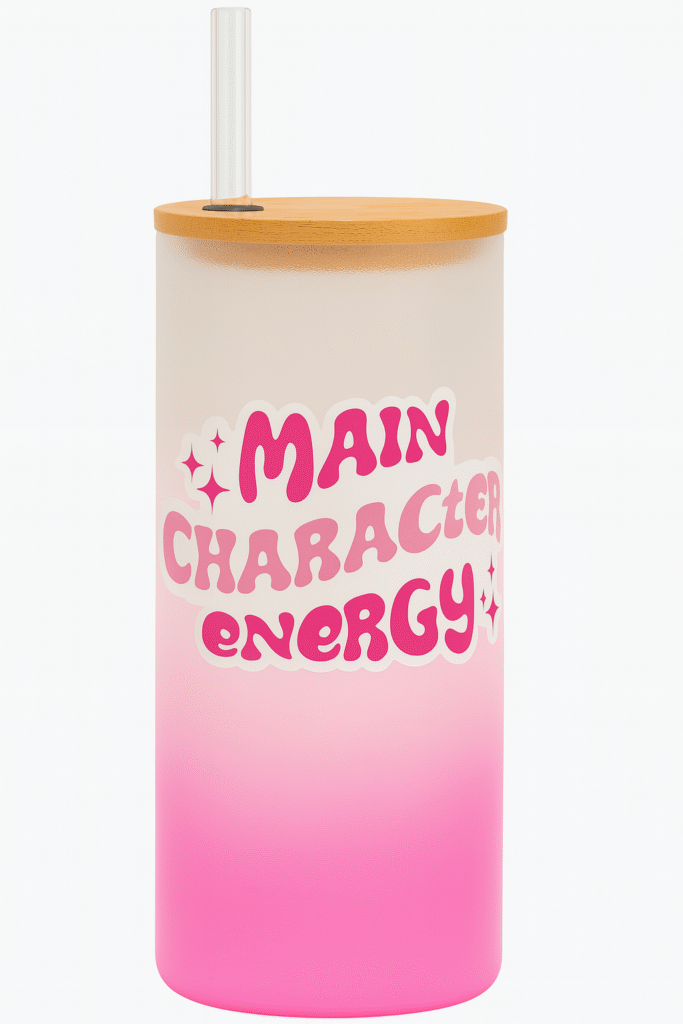 A white and pink gradient Personalized Tumbler for Girls with a bamboo lid and clear straw. One side features an illustration of a stylish girl with a red bandana and sunglasses, and the name "Anaya Sharma." The other side has "MAIN CHARACTER ENERGY" text with star accents.
