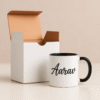 Personalized Black and White Coffee Mug with Name or Logo interior and handle on a wooden table, next to an open book and a small flower.