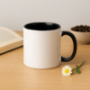 Personalized Black and White Coffee Mug with Name or Logo interior and handle on a wooden table, next to an open book and a small flower.